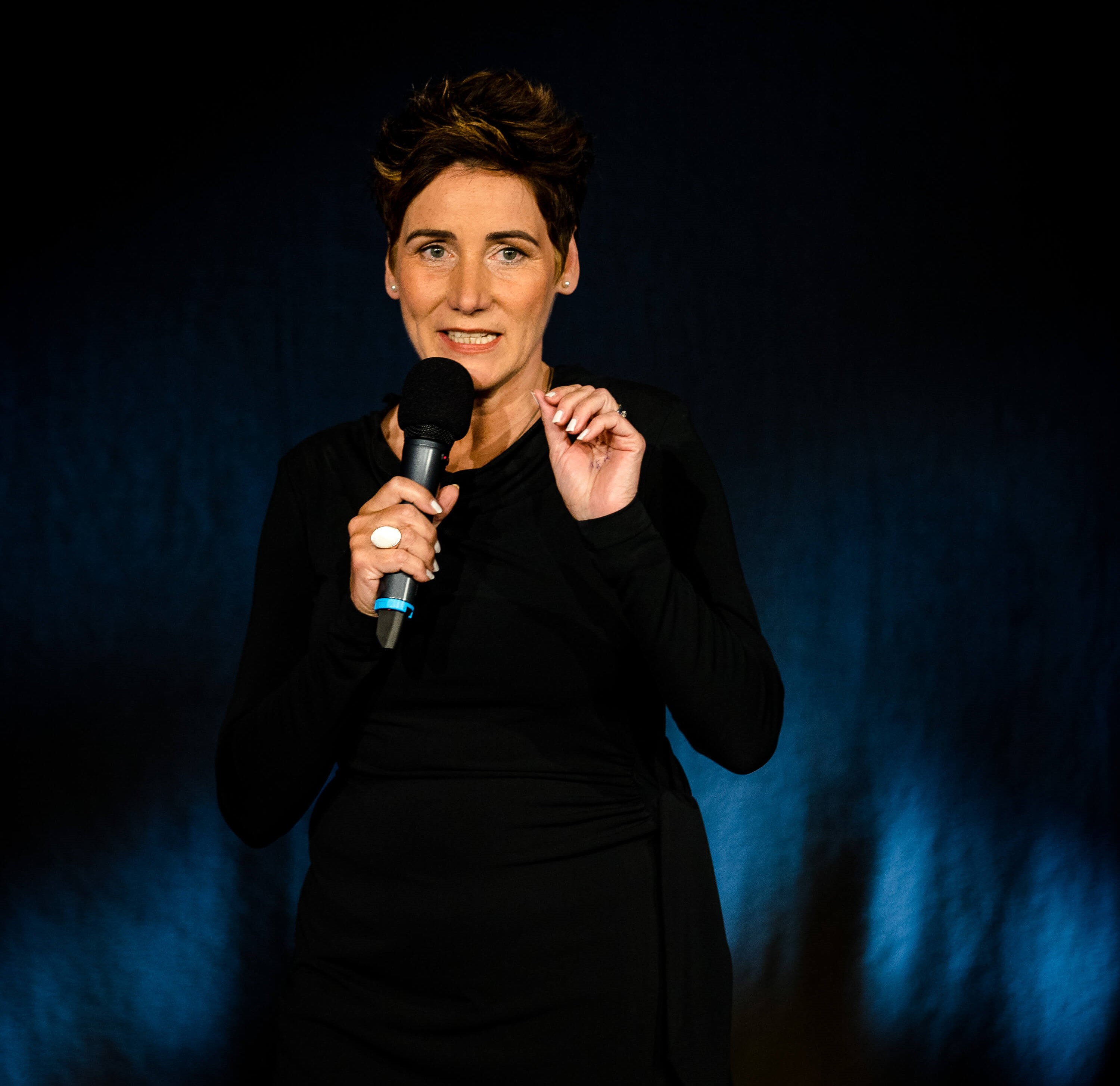 Angela Elis spricht mit Mikrofon auf der Bühne